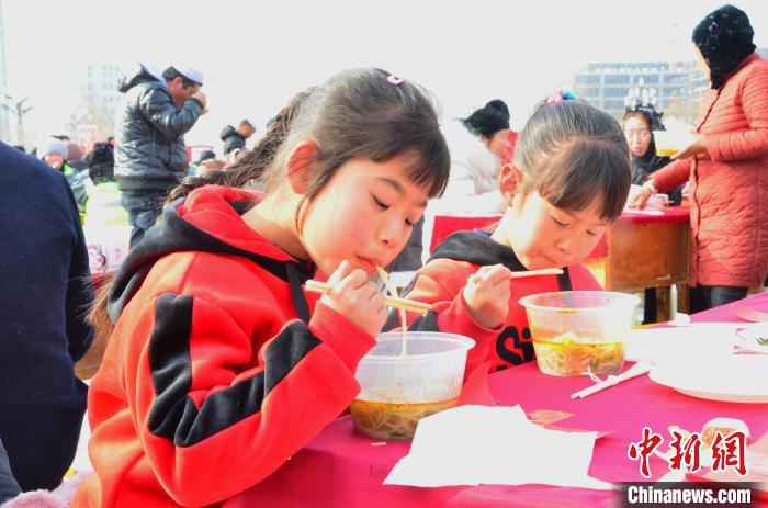 图为活动现场的小朋友正在吃化隆拉面。 鲁丹阳 摄 青海“拉面之乡”千人共享幸福面 1.7万余家拉面店创造130亿年产值