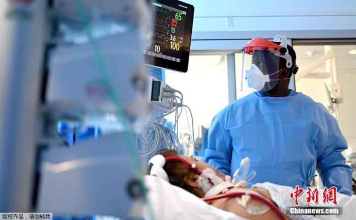 图为英国剑桥皇家帕普沃斯医院重症监护室,一名穿戴防护设备的临床工作人员在护理新冠肺炎患者。 4月以来全球日均新增8万确诊病例 德国“弹性解封”